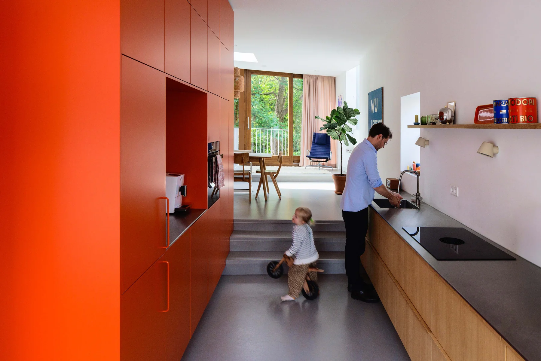 Red kitchen connecting street level and dining area